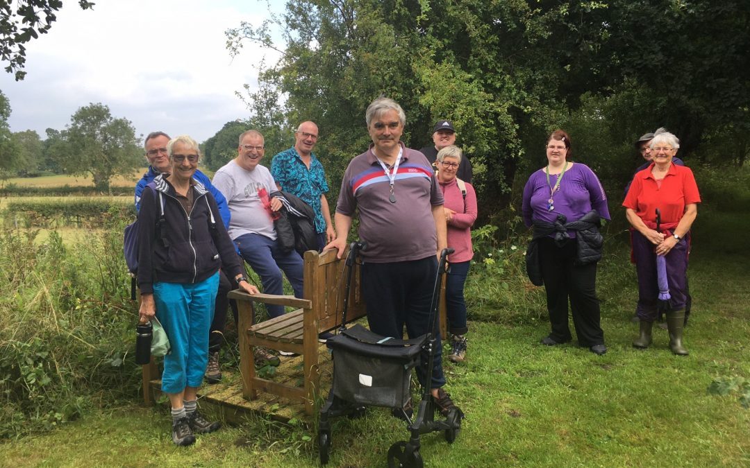 A group of open country members and volunteers in the countryside. It is a summer's day