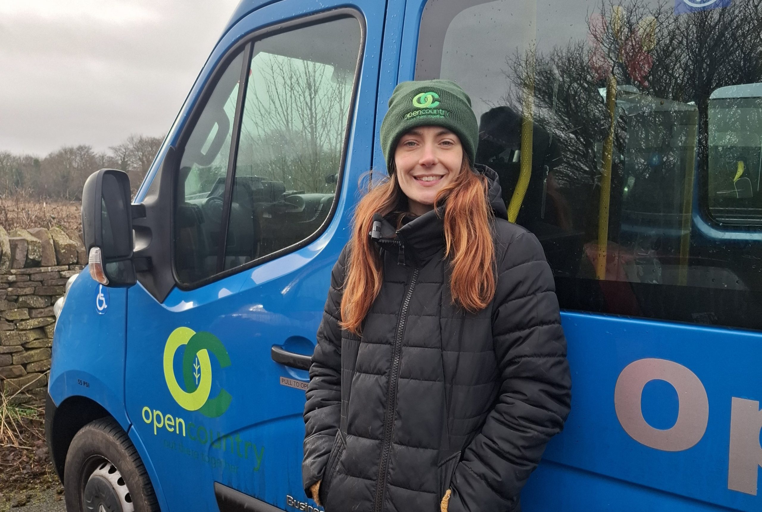 A woman standing in front of a minibus