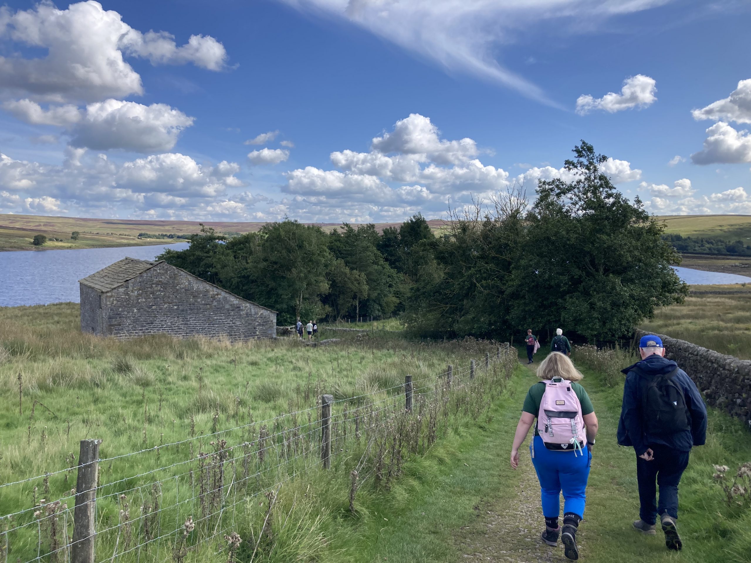 A group walking next to a reservoir